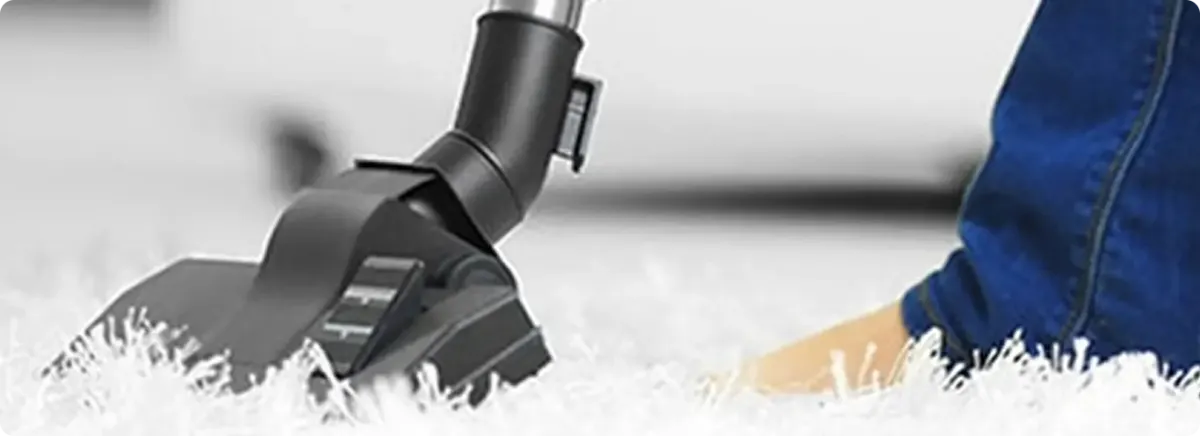 Close-up of a professional vacuuming a white carpet in Ooltewah.